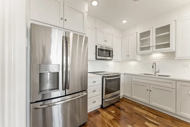 a kitchen with a sink stainless steel appliances and a refrigerator