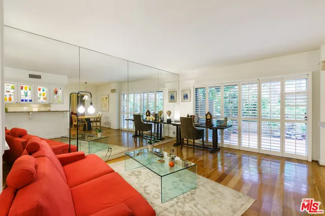 a living room filled with furniture windows and view of kitchen