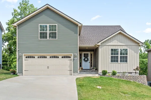 a front view of a house with a garden and yard