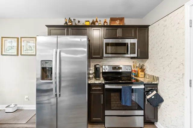 a kitchen with stainless steel appliances granite countertop a stove microwave and refrigerator