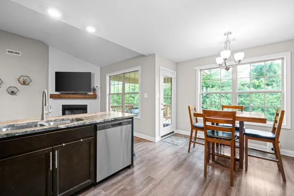 a kitchen with a table chairs sink and wooden floor