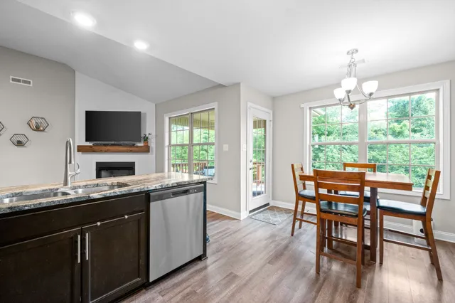 a kitchen with a table chairs sink and wooden floor