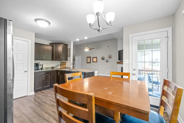 a kitchen with stainless steel appliances granite countertop a sink dishwasher a stove refrigerator and island with wooden floor