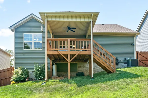 a view of a house with a yard and deck area