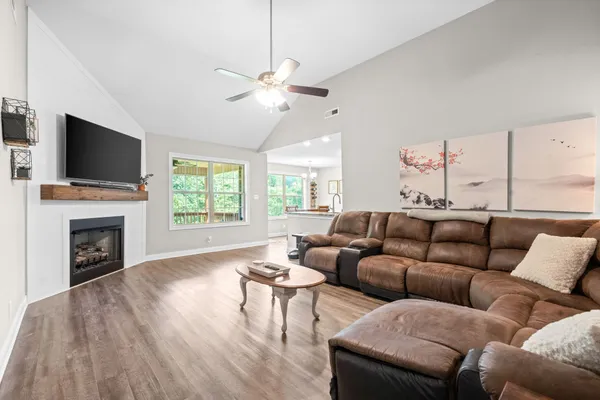 a living room with furniture a fireplace and a flat screen tv