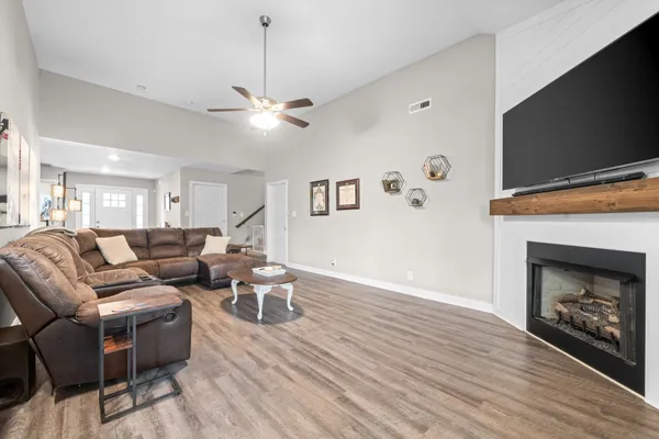 a living room with furniture a fireplace and a flat screen tv