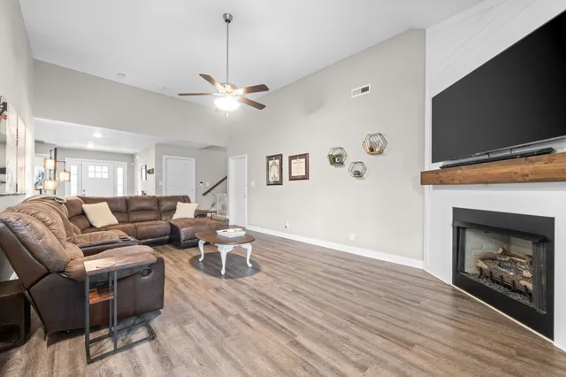 a living room with furniture a fireplace and a flat screen tv
