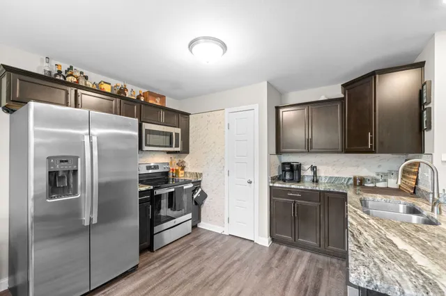 a kitchen with granite countertop a refrigerator and a sink