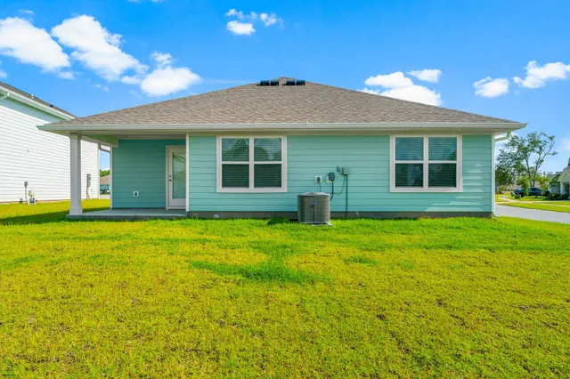 a front view of a house with a yard and potted plants