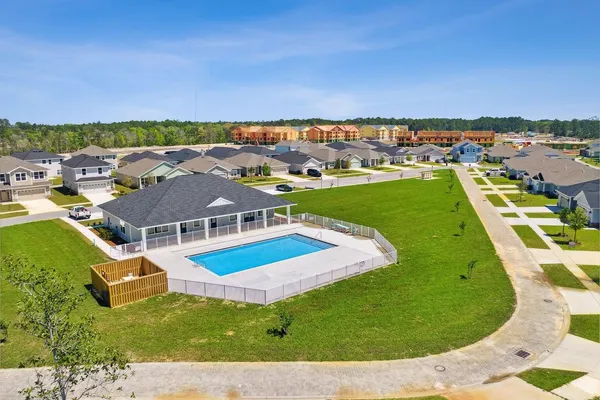 an aerial view of residential houses with outdoor space and swimming pool