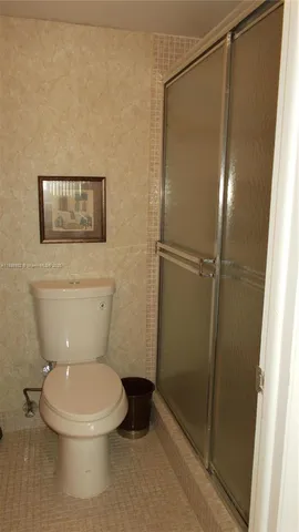 a white toilet sitting next to a shower