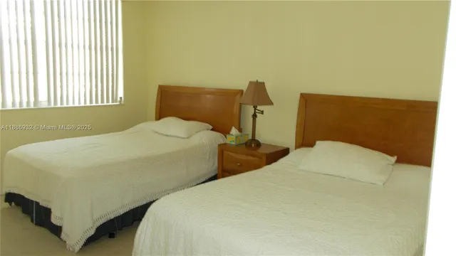 a bedroom with two beds and a window