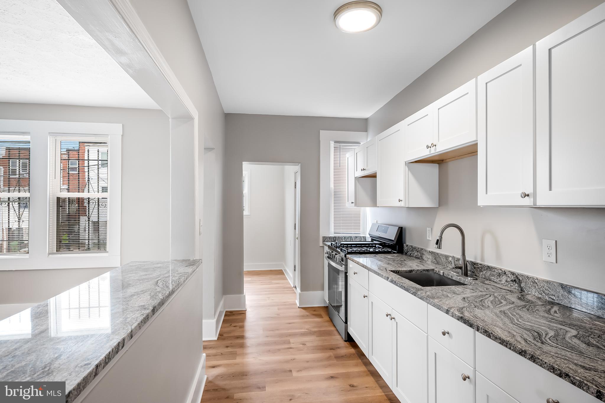 3003 Kentucky Avenue Baltimore, MD 21213 - Photo 11 of 32 a large kitchen with granite countertop a sink and cabinets