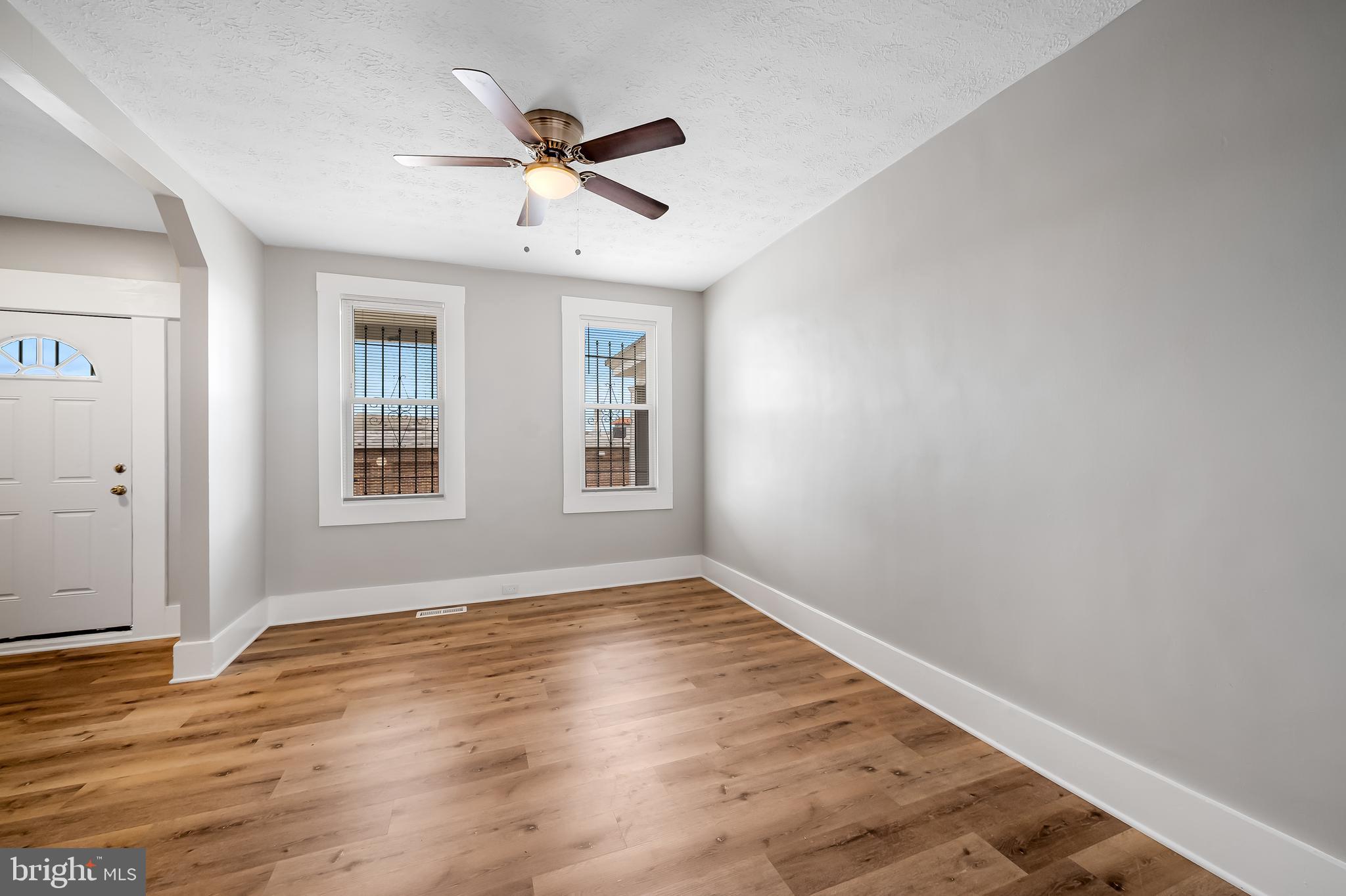 3003 Kentucky Avenue Baltimore, MD 21213 - Photo 6 of 32 an empty room with wooden floor fan and windows