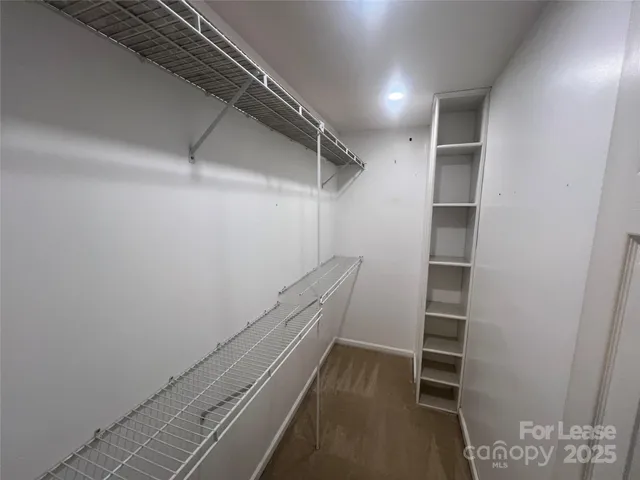 a view of walk in closet with empty racks