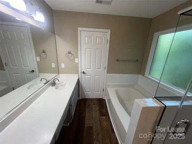 a bathroom with a tub sink and mirror