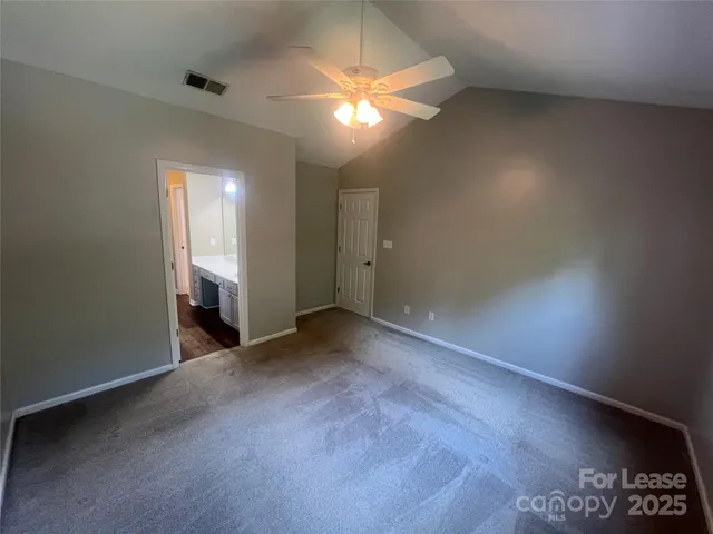 an empty room with closet and a chandelier fan