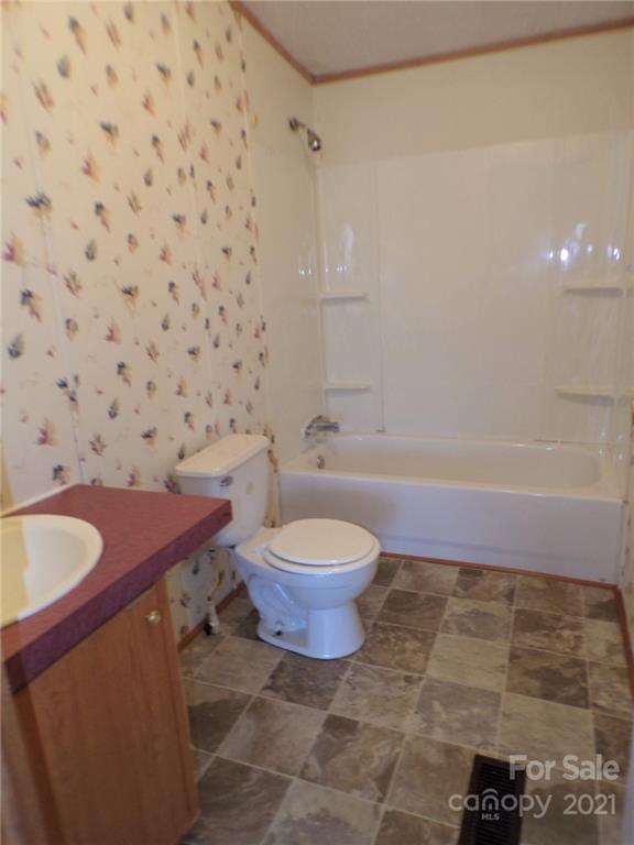 5230 Startown Road Newton, NC 28658 - Photo 8 of 16 a bathroom with a granite countertop bathtub and a toilet