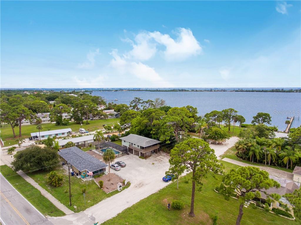 512 South McCall Road Englewood, FL 34223 - Photo 1 of 1 Aerial view of duplex, parking area, caged pool and stilt house - ALL FOR $390,000!