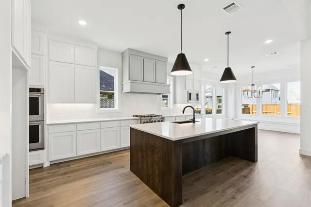 a kitchen with stainless steel appliances kitchen island a sink stove and cabinets