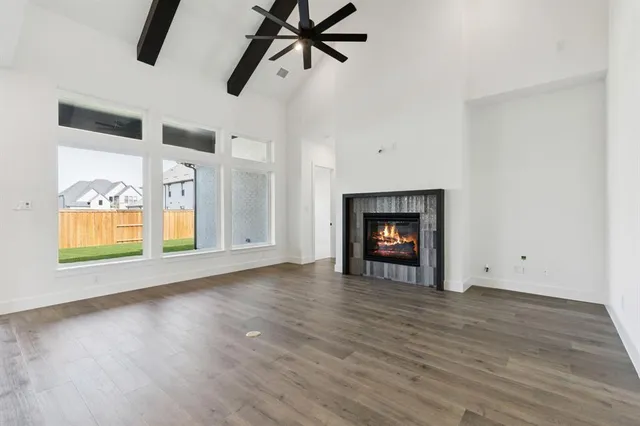 an empty room with wooden floor cabinet and fireplace