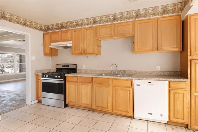 a view of a kitchen with white cabinets and a window
