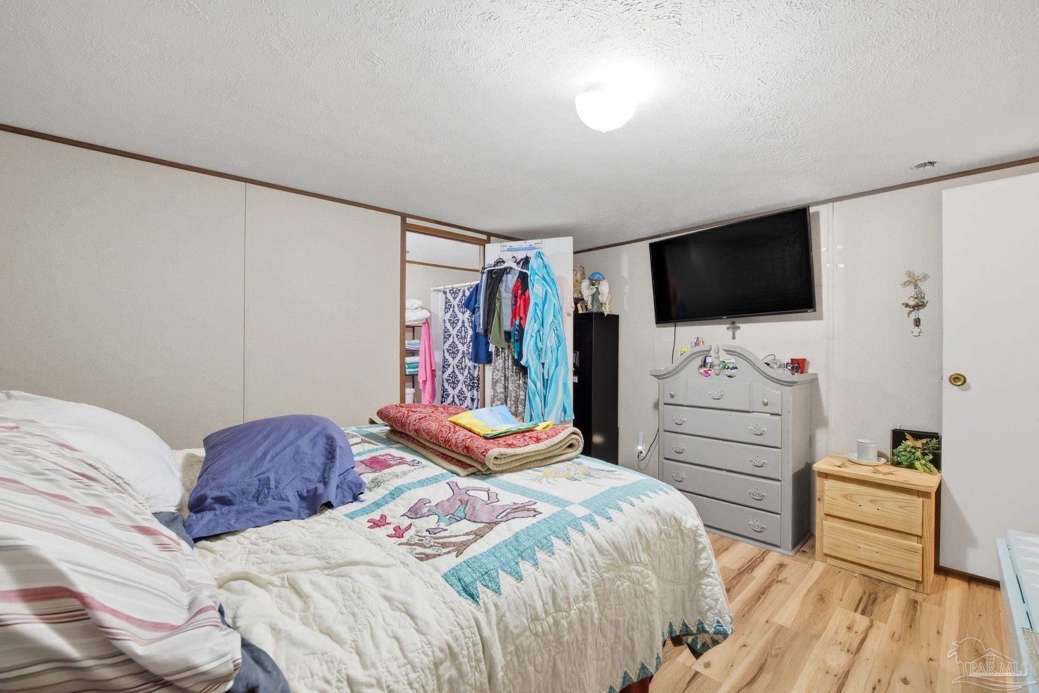 3338 Bob Tolbert Road Navarre, FL 32566 - Photo 12 of 29 a bedroom with a bed and a flat screen tv