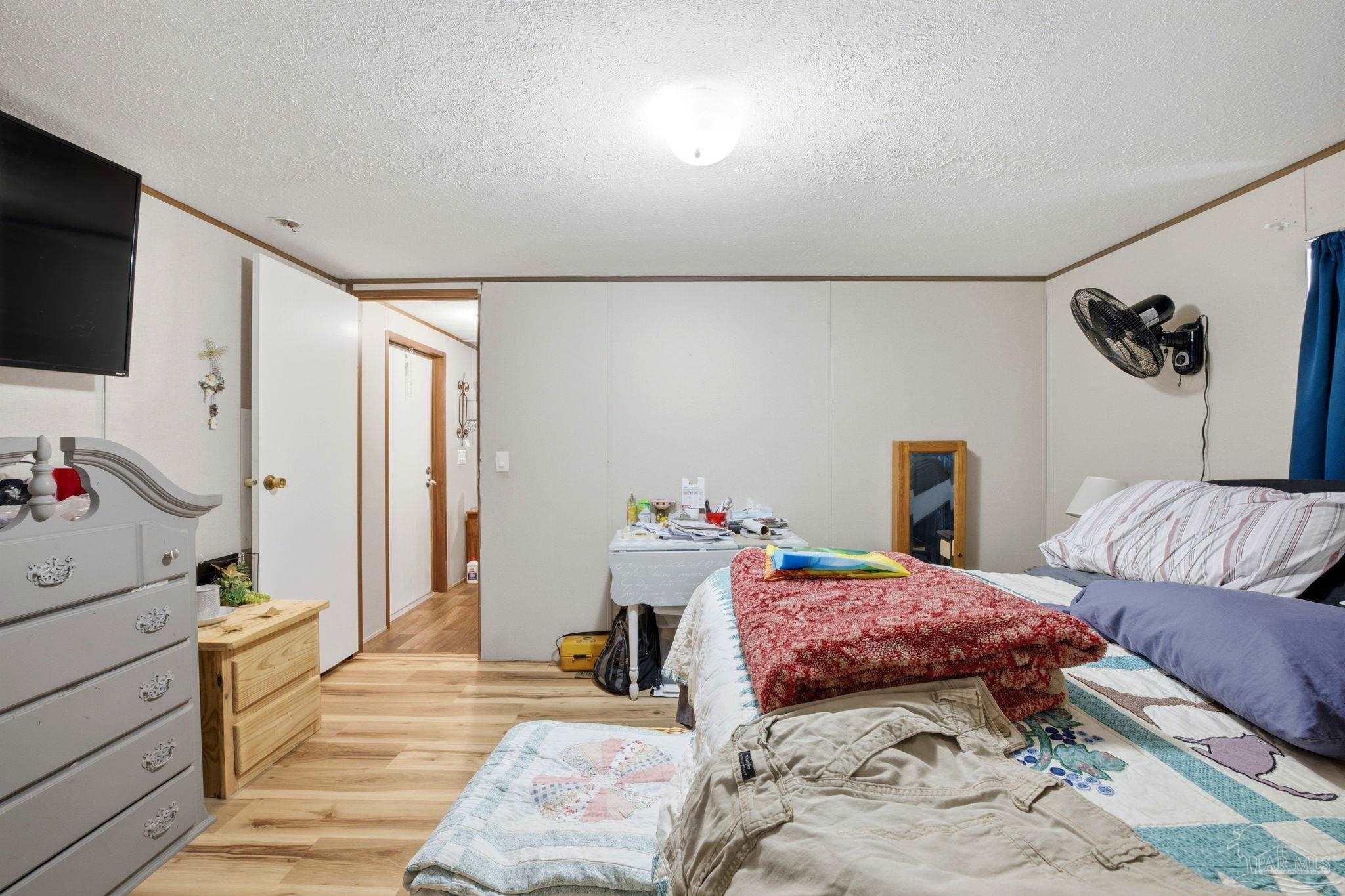 3338 Bob Tolbert Road Navarre, FL 32566 - Photo 13 of 29 a bedroom with a bed a flat screen tv and dresser in it