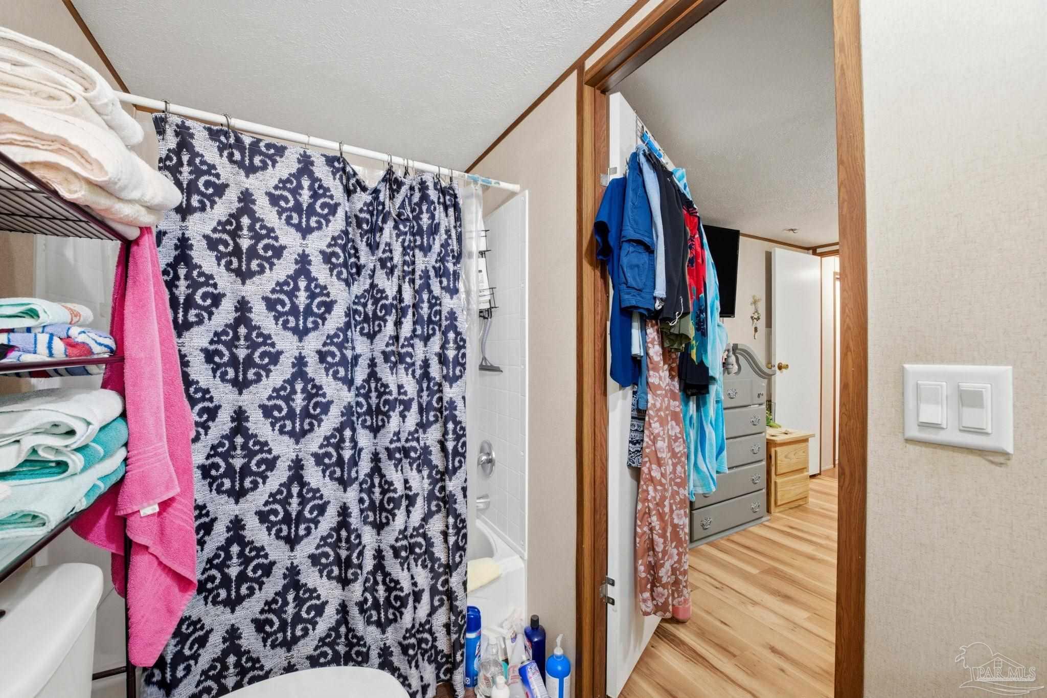 3338 Bob Tolbert Road Navarre, FL 32566 - Photo 16 of 29 a view of a hallway with wooden floor and stairs