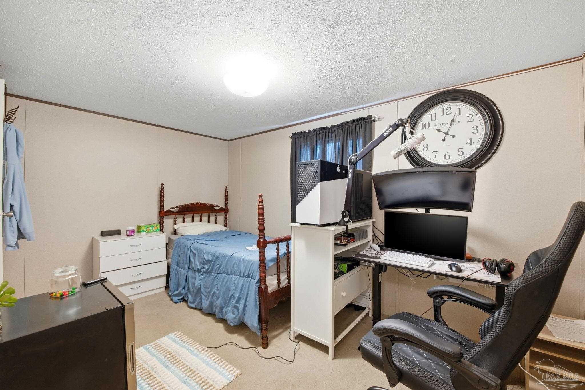 3338 Bob Tolbert Road Navarre, FL 32566 - Photo 17 of 29 a living room with furniture a clock tv and a window