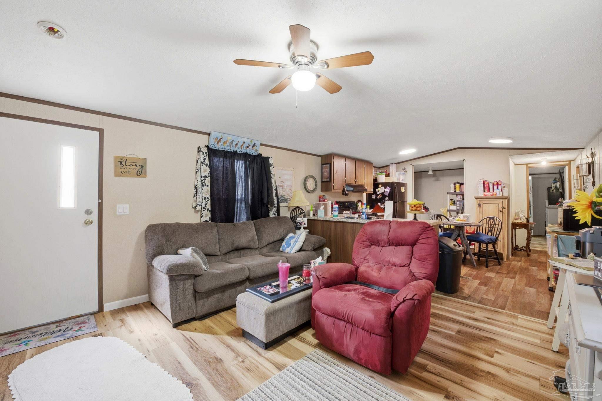 3338 Bob Tolbert Road Navarre, FL 32566 - Photo 6 of 29 a living room with furniture kitchen view and a chandelier