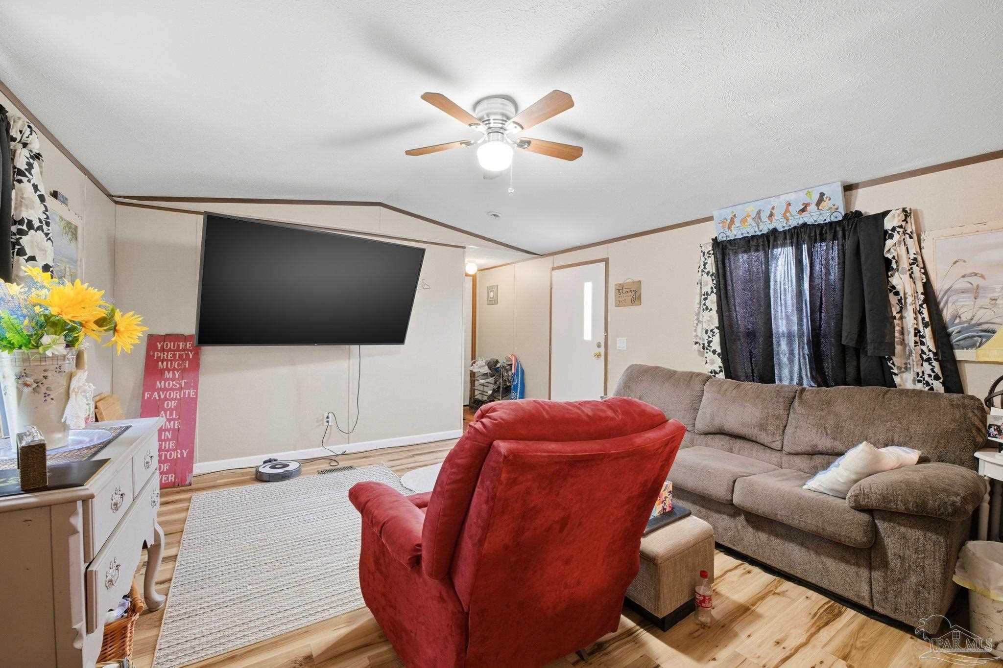 3338 Bob Tolbert Road Navarre, FL 32566 - Photo 7 of 29 a living room with furniture a flat screen tv and a window