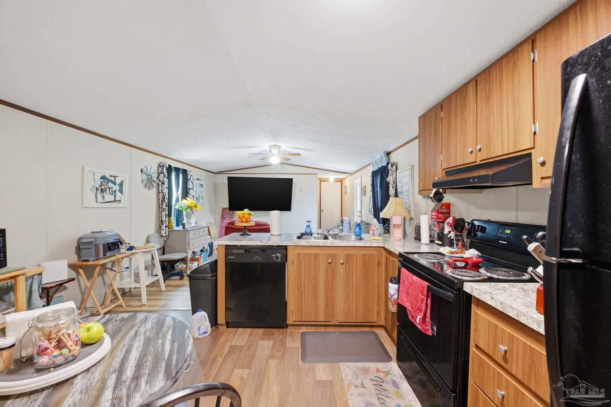 3338 Bob Tolbert Road Navarre, FL 32566 - Photo 10 of 29 a view of a kitchen with kitchen island a large counter top space a sink stainless steel appliances and cabinets