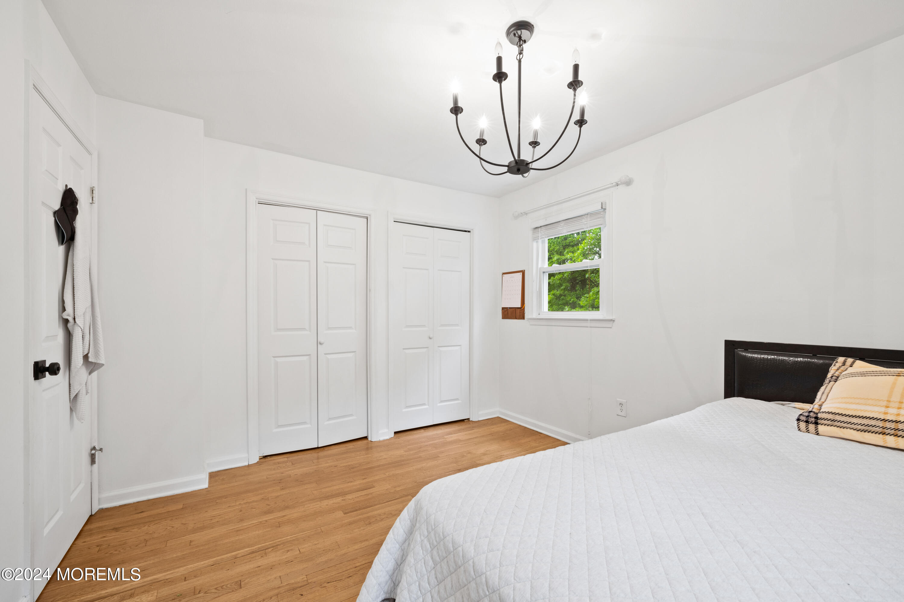 429 Cottrell Road Matawan, NJ 07747 - Photo 6 of 22 a bedroom with a bed and a chandelier