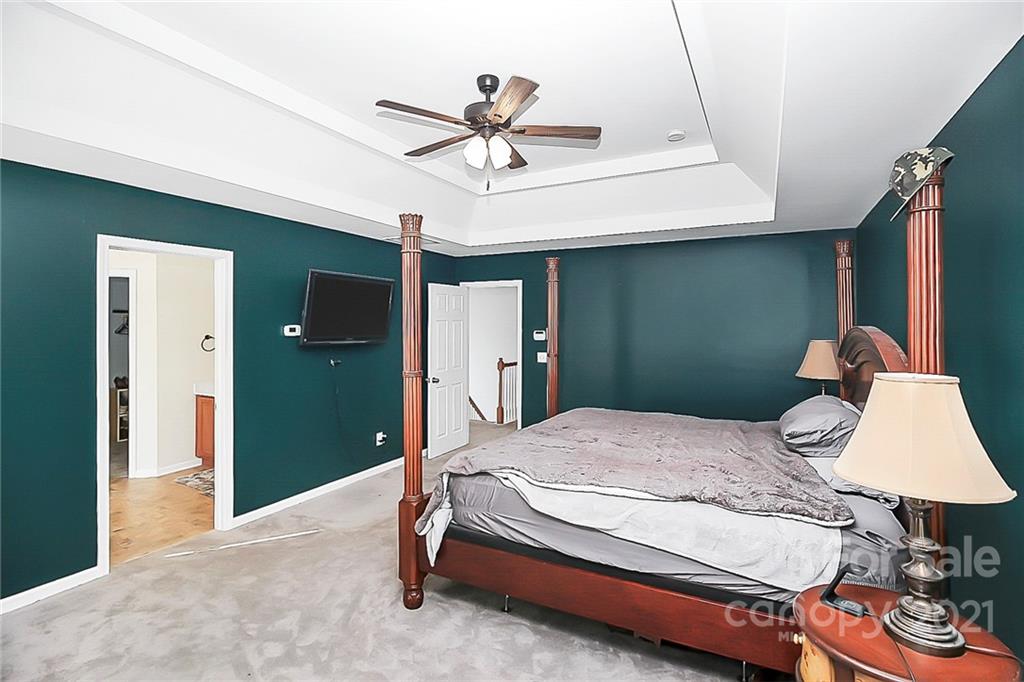 7769 East Berkeley Road Denver, NC 28037 - Photo 18 of 31 a bedroom with a bed and a chandelier