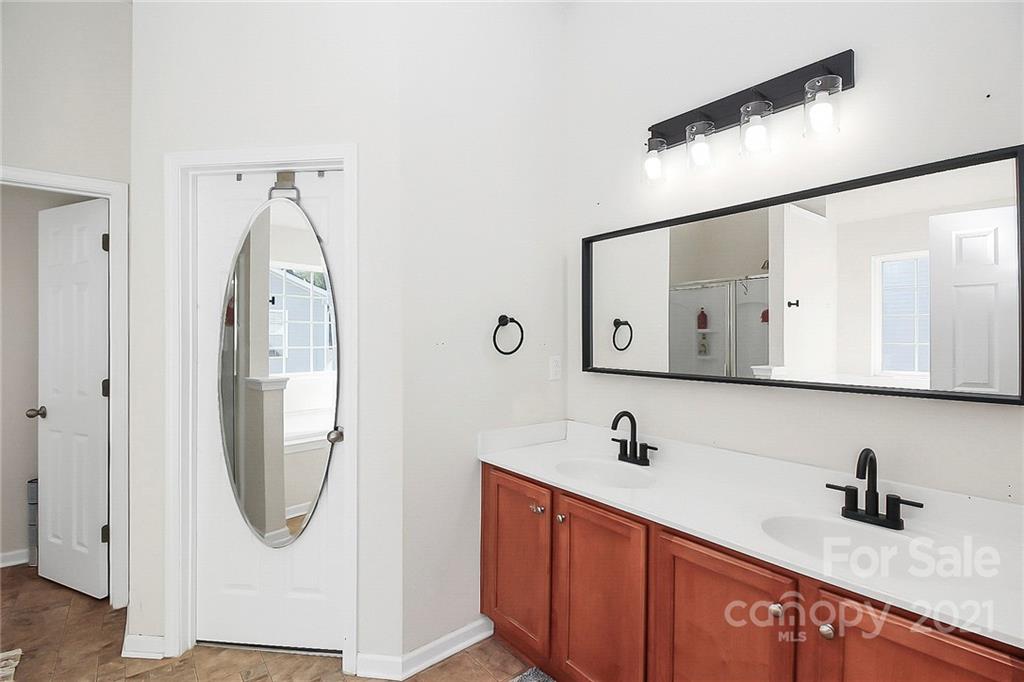 7769 East Berkeley Road Denver, NC 28037 - Photo 20 of 31 a bathroom with a double vanity sink and a mirror
