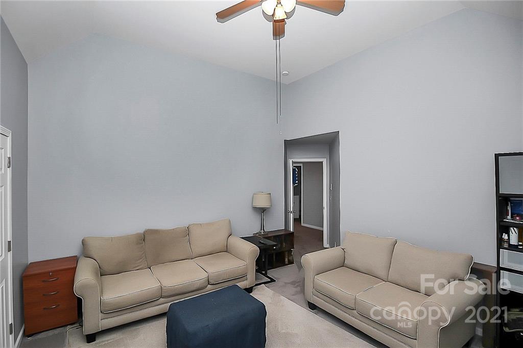 7769 East Berkeley Road Denver, NC 28037 - Photo 23 of 31 a living room with furniture and a chandelier