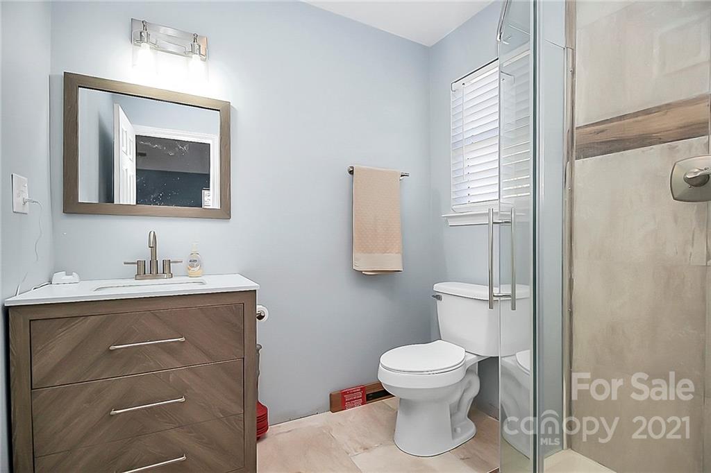 7769 East Berkeley Road Denver, NC 28037 - Photo 26 of 31 a bathroom with a toilet sink vanity and mirror