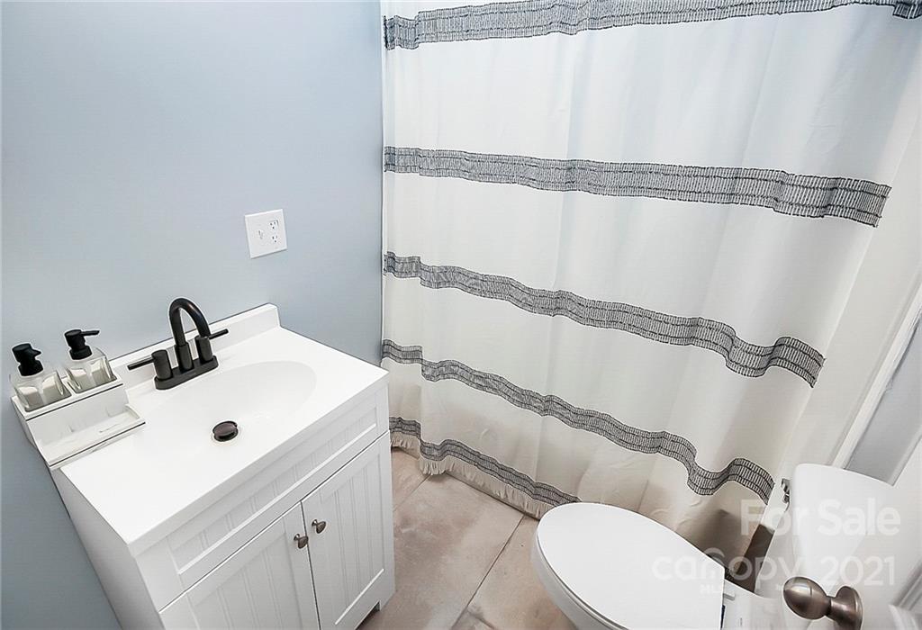 7769 East Berkeley Road Denver, NC 28037 - Photo 27 of 31 a bathroom with a sink and mirror with toilet