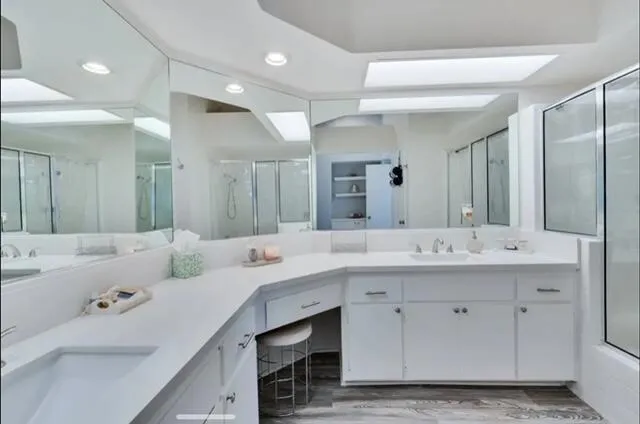 a bathroom with a sink double vanity granite and a mirror