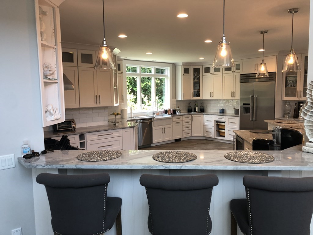 15 Wyoma Road Gloucester, MA 01930 - Photo 3 of 11 a kitchen with stainless steel appliances granite countertop a sink a stove a refrigerator a dining table and chairs