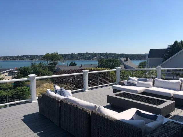 a view of a roof deck with couches and sky view