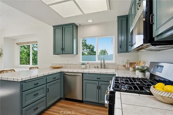 an empty room with wooden floor and ceiling fan