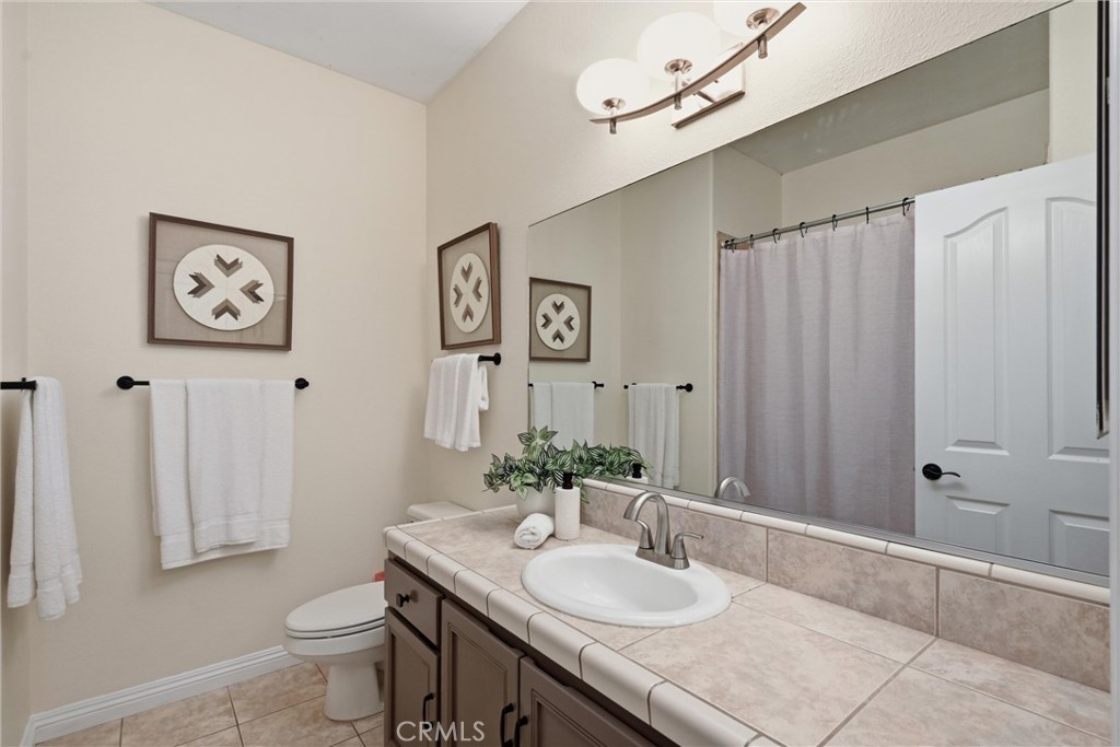 19345 Moon Ridge Road Hidden Valley Lake, CA 95467 - Photo 46 of 64 a bathroom with a granite countertop sink a toilet and a mirror