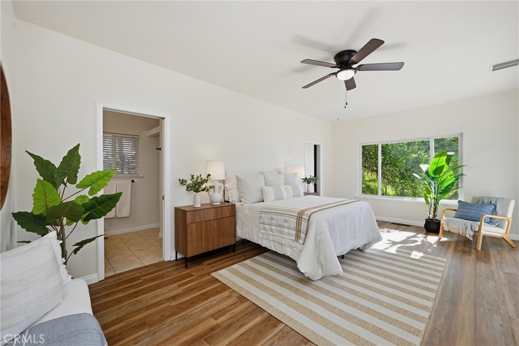 19345 Moon Ridge Road Hidden Valley Lake, CA 95467 - Photo 54 of 64 a spacious bedroom with a bed and a chandelier
