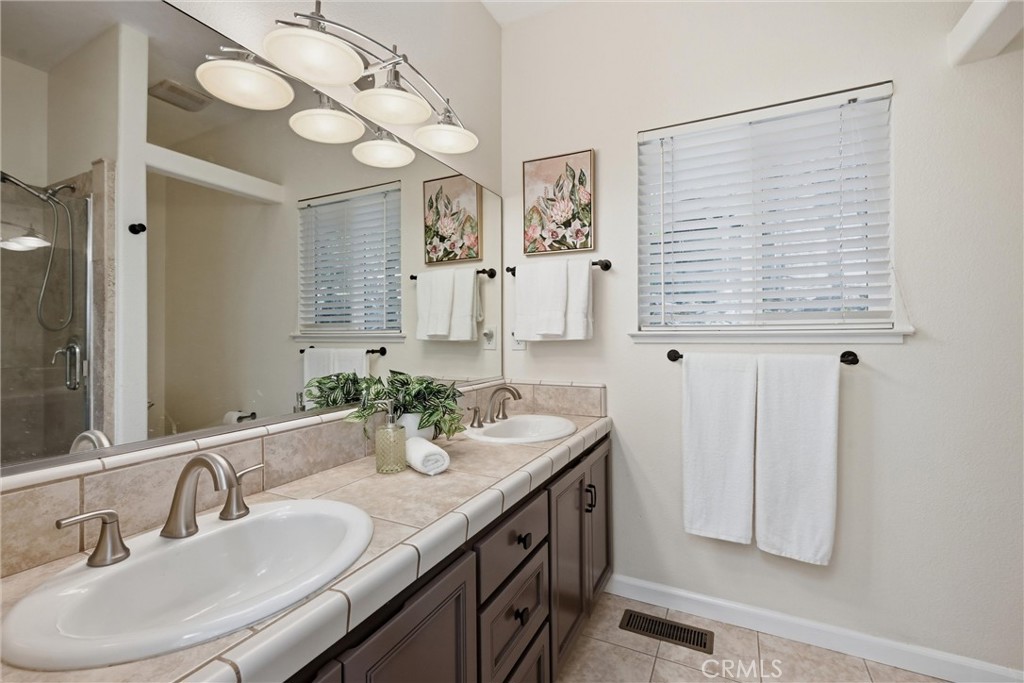 19345 Moon Ridge Road Hidden Valley Lake, CA 95467 - Photo 56 of 64 a bathroom with double vanity sink and a mirror
