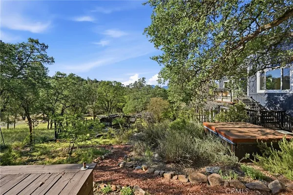 a backyard of a house with table and chairs under an umbrella