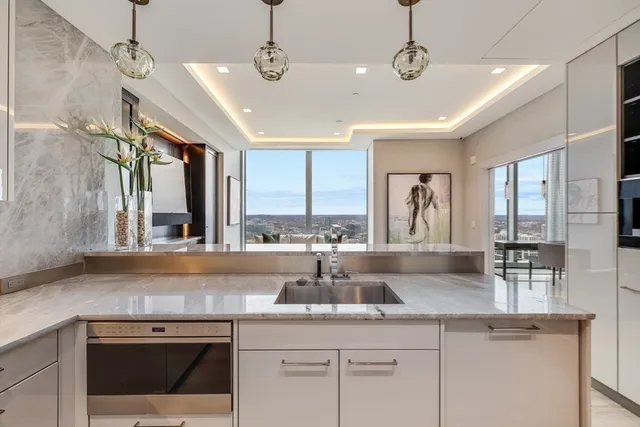 a kitchen with stainless steel appliances granite countertop a sink a counter space and a view of living room