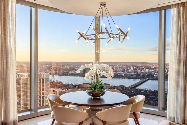 a dining room with a glass top table and chairs