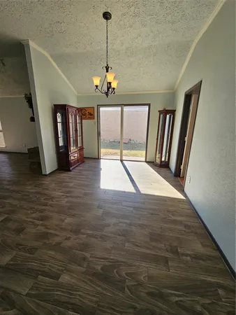 a view of empty room with wooden floor and window